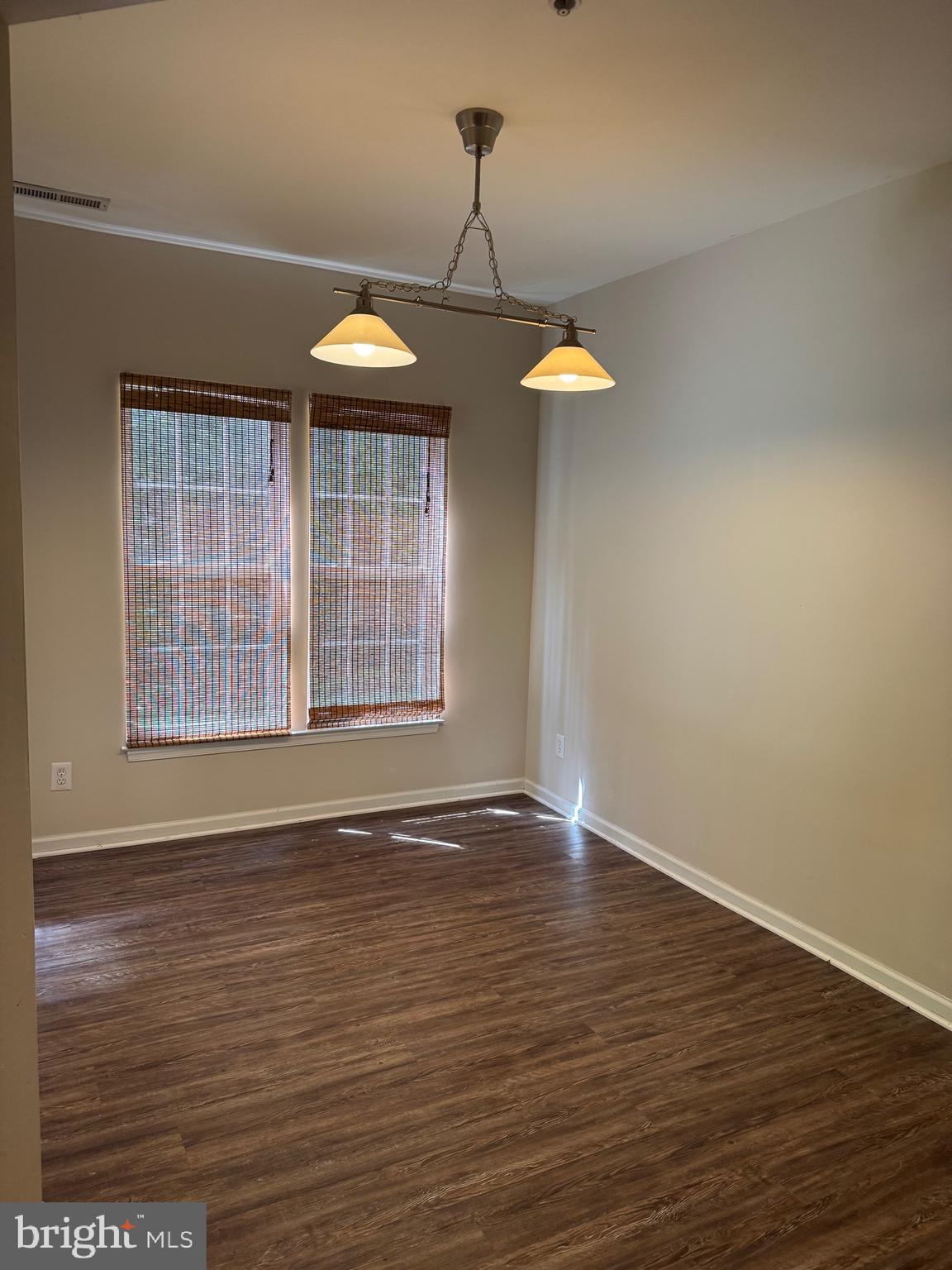 2003 Whispering Ponds Court, Unit 1C Salisbury, MD 21804 - Photo 5 of 12 an empty room with wooden floor and windows