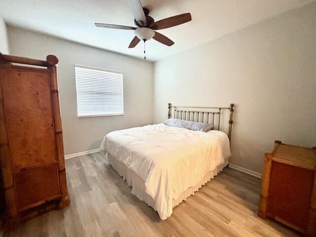 10520 Southwest Stephanie Way, Unit 2202 Port St. Lucie, FL 34987 - Photo 5 of 9 a bedroom with a bed and wooden floor