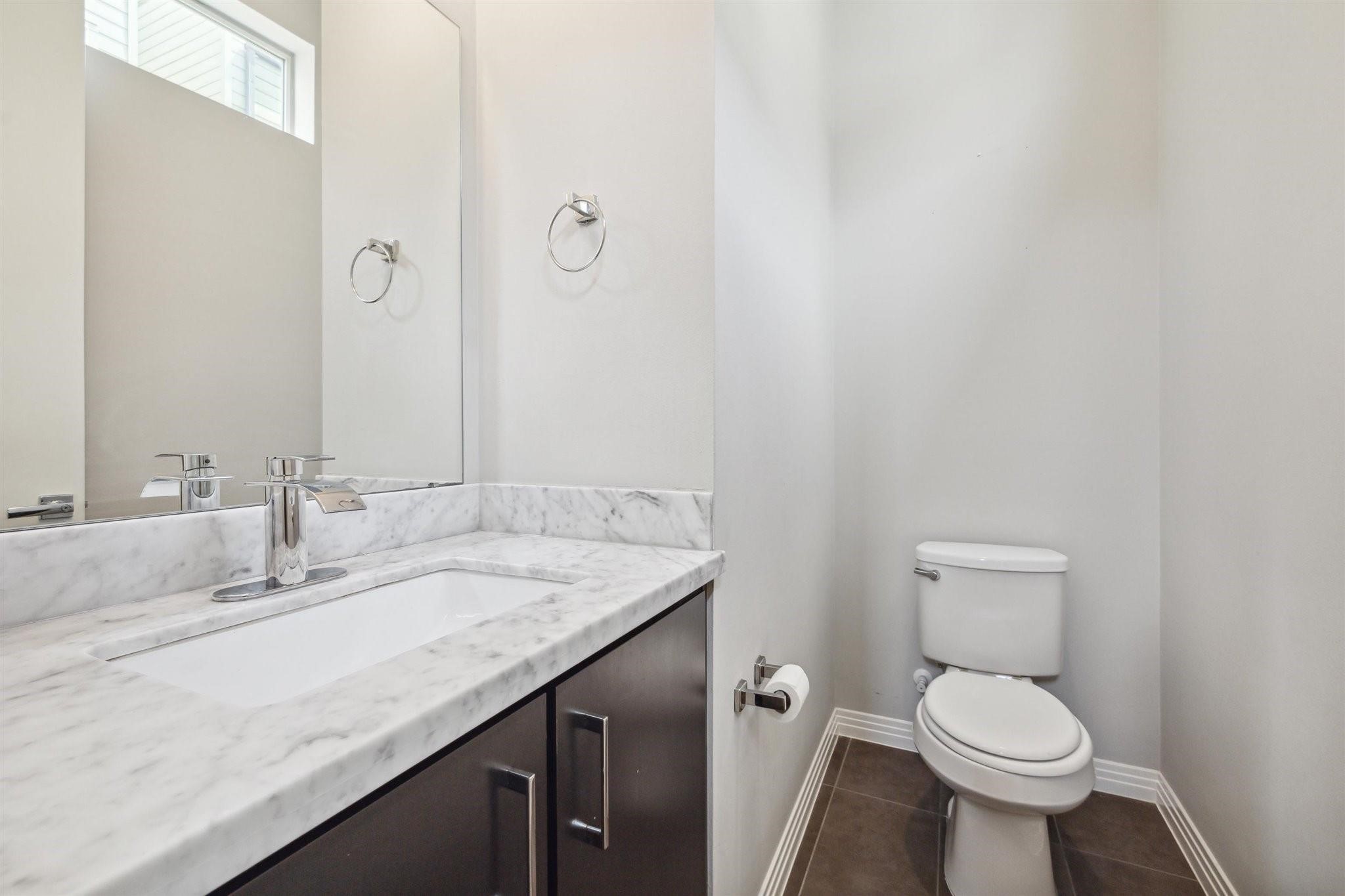 1630 Dennis Street Houston, TX 77004 - Photo 18 of 33 a bathroom with a granite countertop toilet sink and mirror