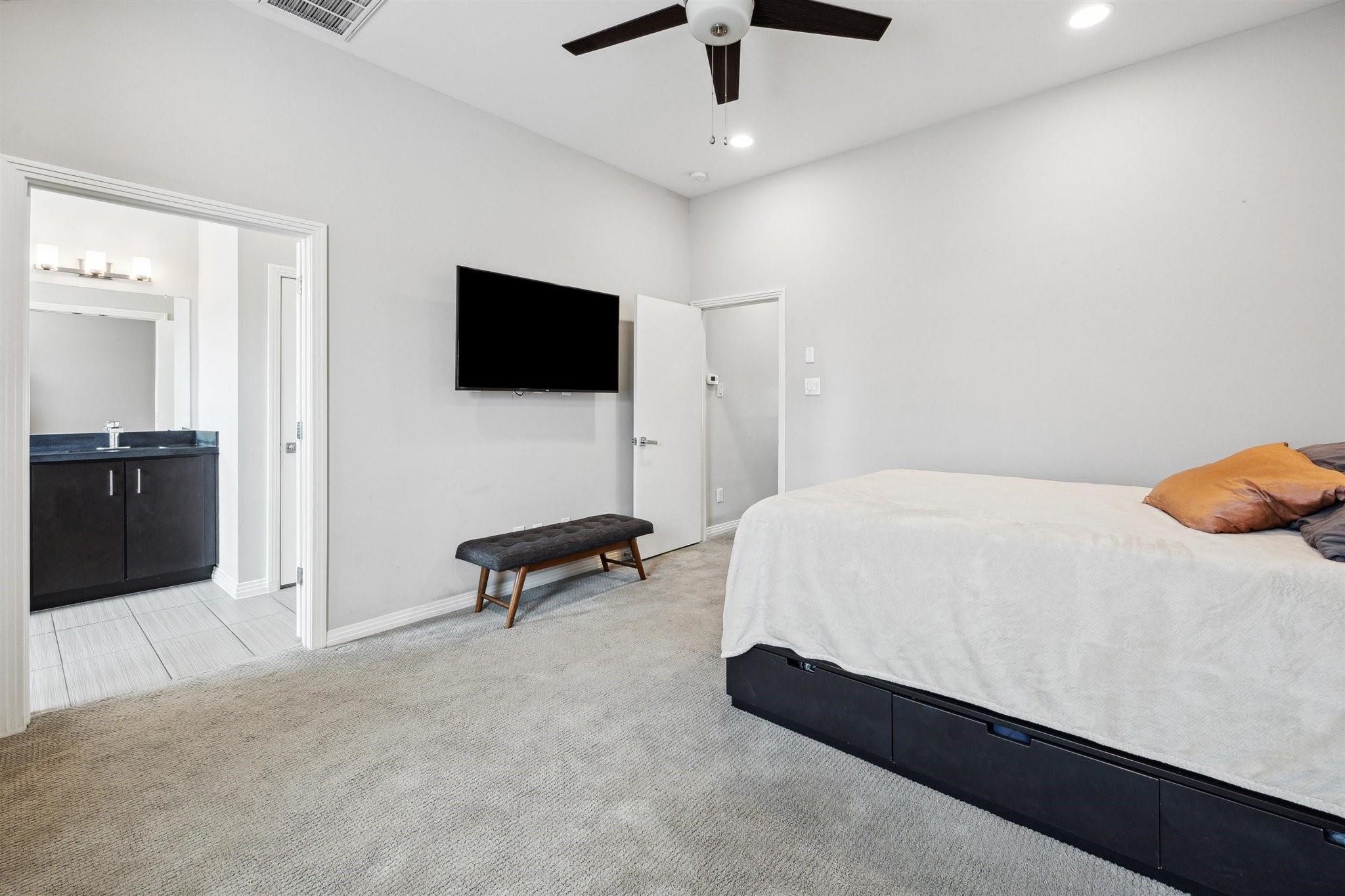 1630 Dennis Street Houston, TX 77004 - Photo 22 of 33 a spacious bedroom with a bed and a flat screen tv