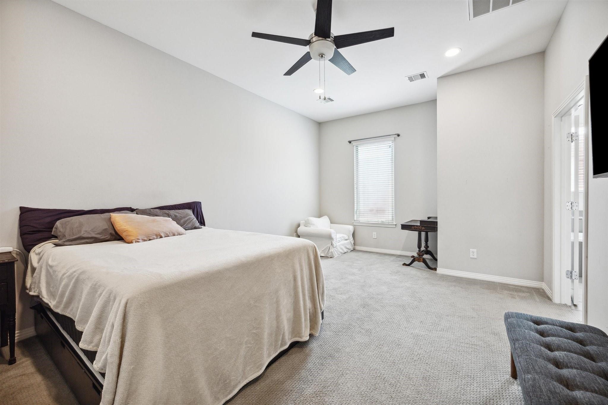 1630 Dennis Street Houston, TX 77004 - Photo 23 of 33 a spacious bedroom with a bed a couch and a chandelier