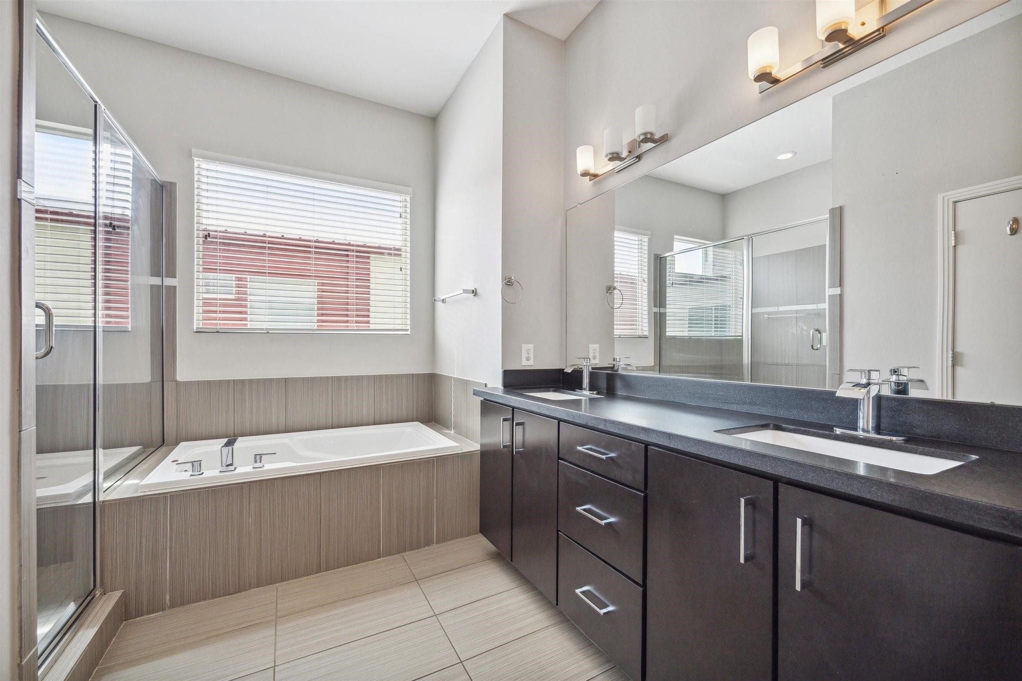 1630 Dennis Street Houston, TX 77004 - Photo 25 of 33 a bathroom with a sink double vanity granite tub shower and mirror