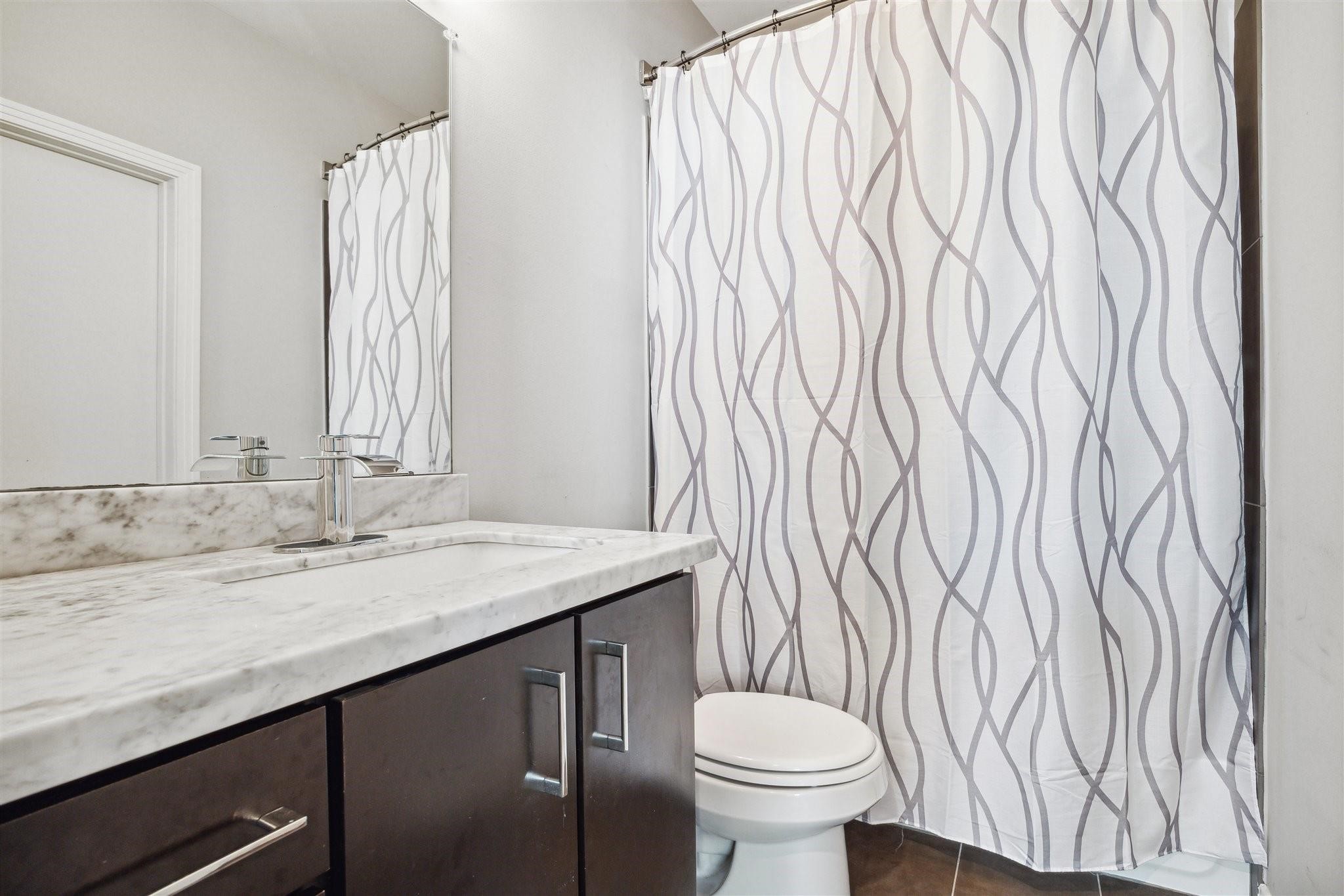 1630 Dennis Street Houston, TX 77004 - Photo 28 of 33 a bathroom with a granite countertop sink and a mirror