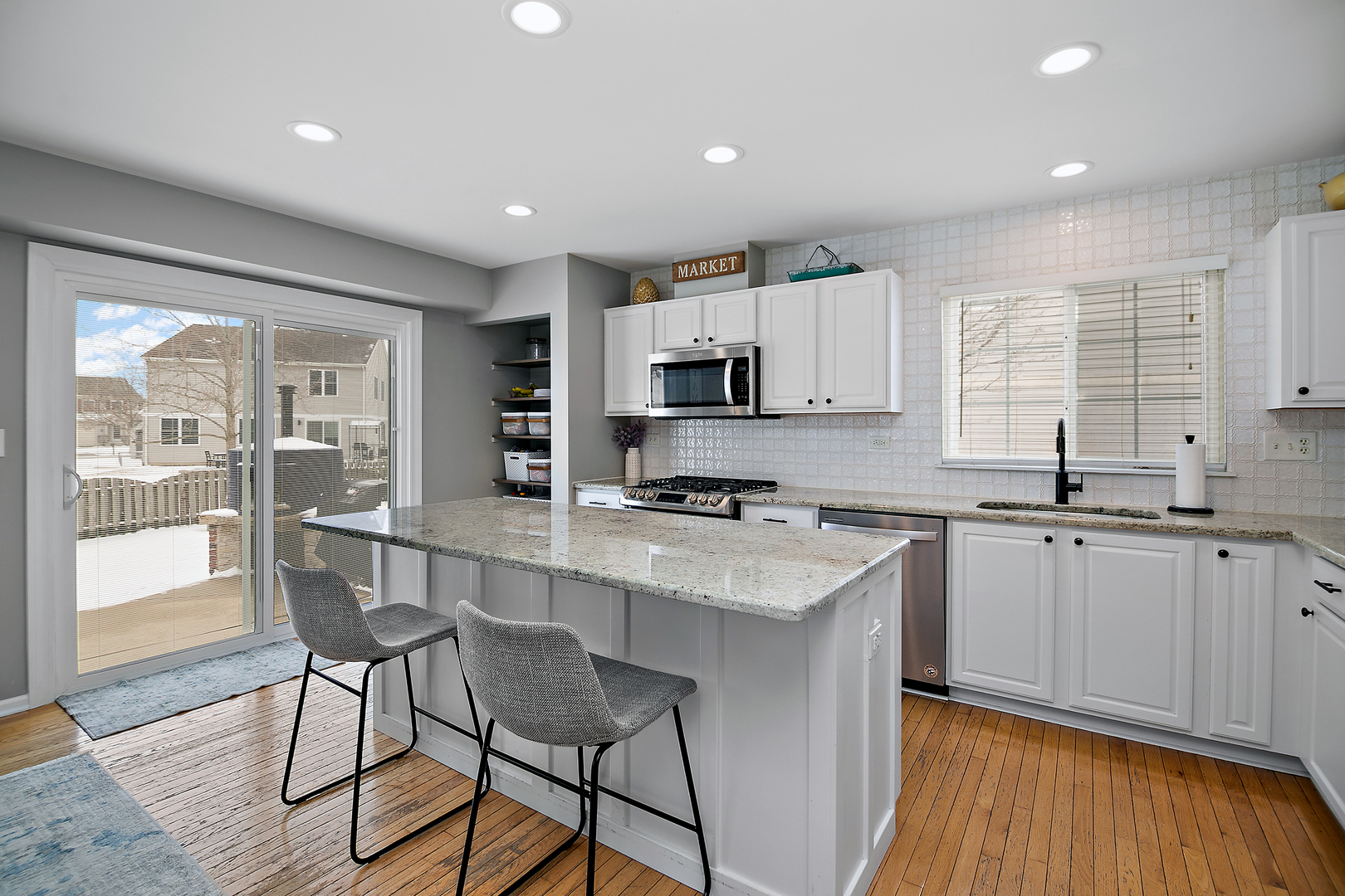1675 Rosehall Lane Elgin, IL 60123 - Photo 17 of 49 a kitchen with stainless steel appliances granite countertop a stove top oven a sink dishwasher a dining table and chairs with wooden floor