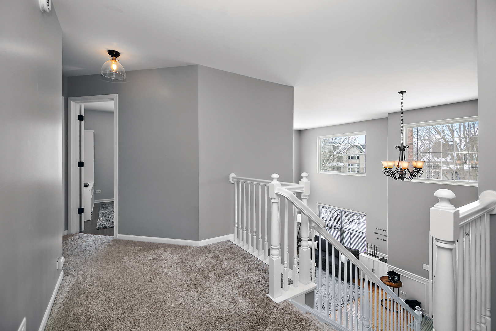 1675 Rosehall Lane Elgin, IL 60123 - Photo 22 of 49 a view of staircase with lots of frames on wall and a chandelier