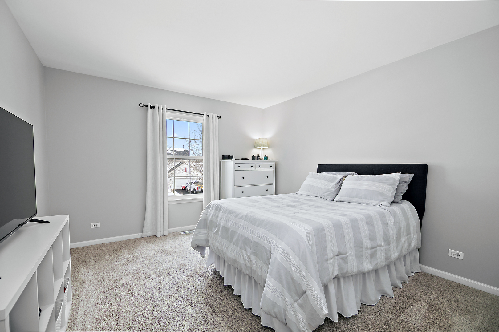 1675 Rosehall Lane Elgin, IL 60123 - Photo 32 of 49 a bedroom with a bed and a flat tv screen on dresser
