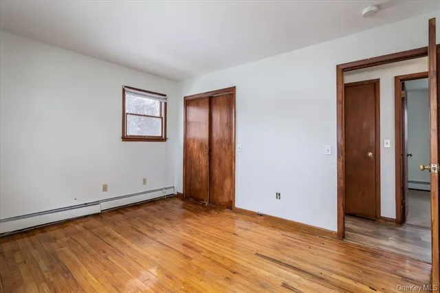 an empty room with wooden floor and closet