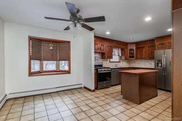 a kitchen with stainless steel appliances granite countertop a stove top oven a sink and a refrigerator