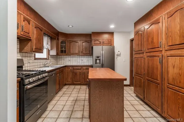 a kitchen with stainless steel appliances granite countertop a refrigerator and a stove