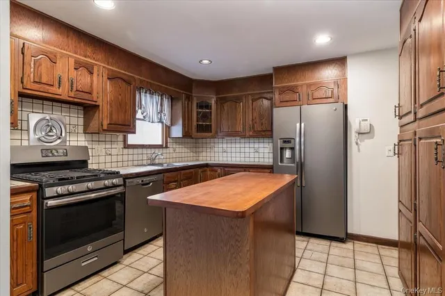 a kitchen with stainless steel appliances granite countertop a refrigerator stove and sink