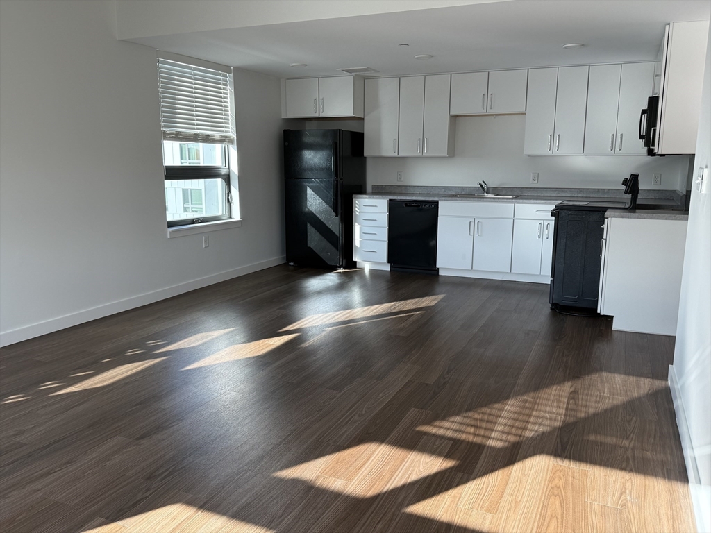 a kitchen with stainless steel appliances wooden floors and a window