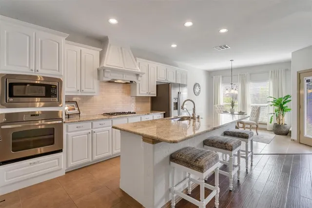 a living room with stainless steel appliances furniture and a flat screen tv
