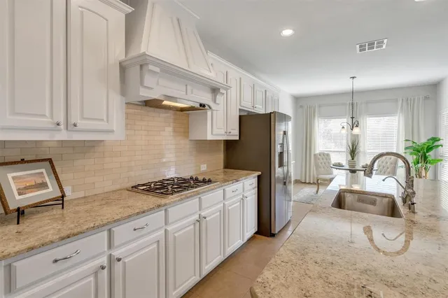 a kitchen with granite countertop a sink stainless steel appliances and cabinets