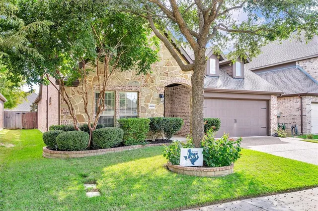 a front view of a house with a yard and potted plants