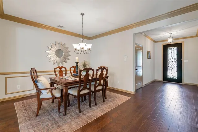 a dining room with furniture a chandelier and wooden floor