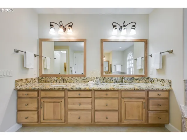 a bathroom with a granite countertop tub a sink and a large mirror