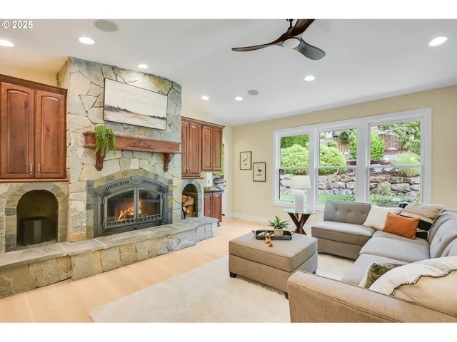 a living room with furniture kitchen view and a large window