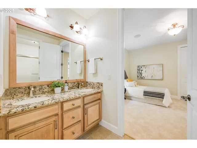 a en suite bathroom with a granite countertop sink and a mirror