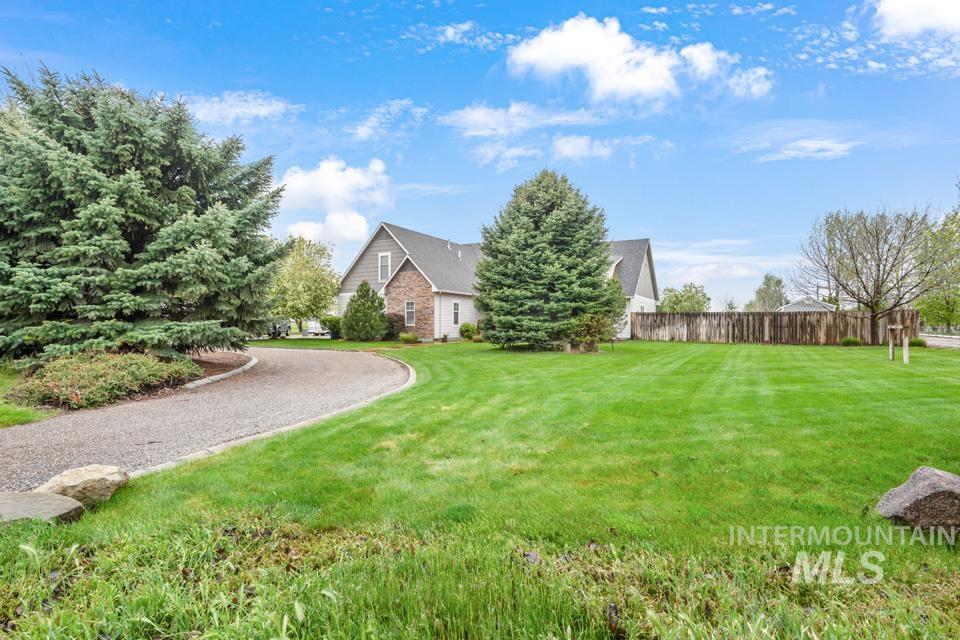 8271 Washoe Road Fruitland, ID 83619 - Photo 5 of 29 Spacious green lawn surrounding a residence with stone and siding facade