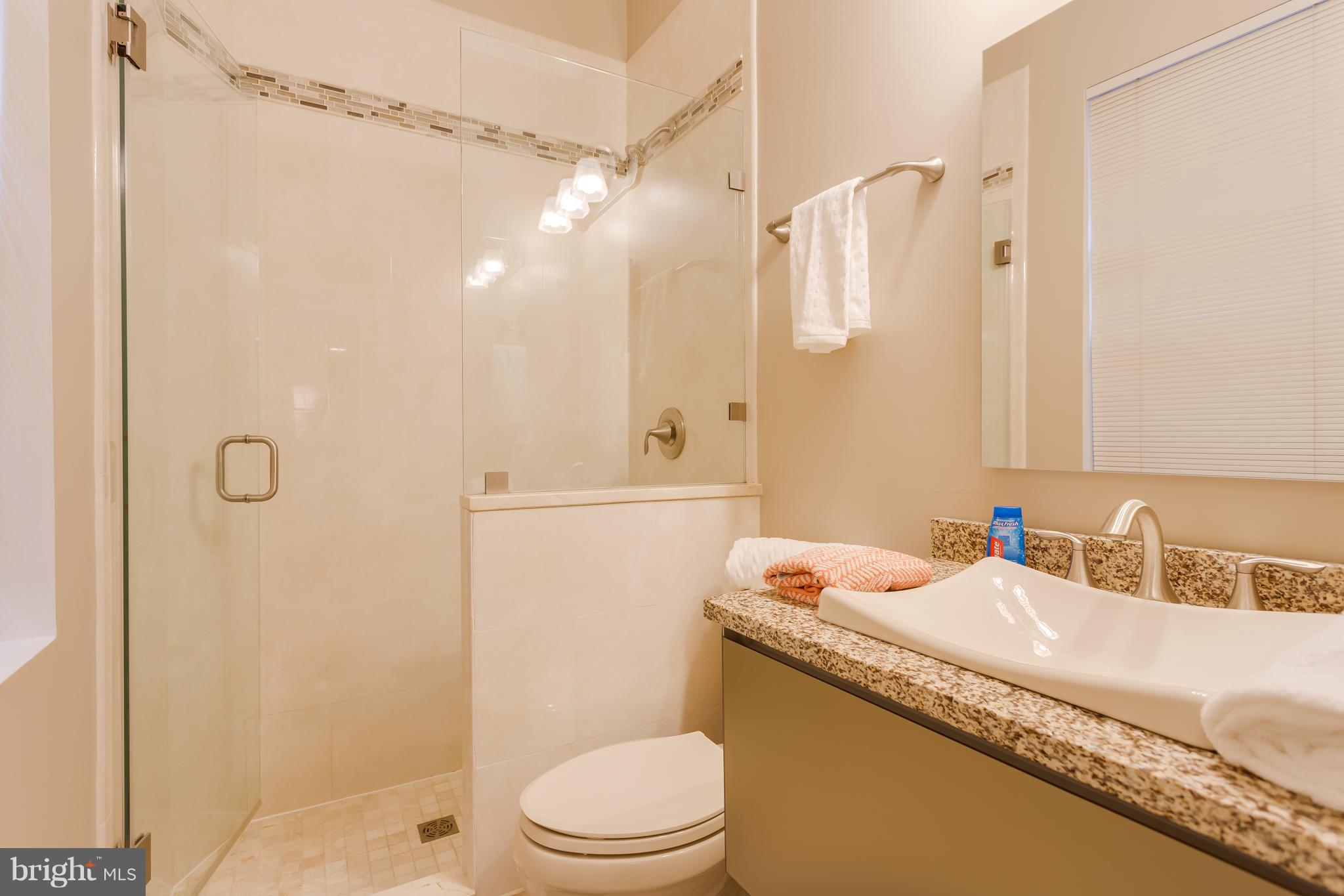 1603 16th Street Northwest, Unit 3 Washington, DC 20009 - Photo 20 of 30 a bathroom with a granite countertop sink a toilet and shower