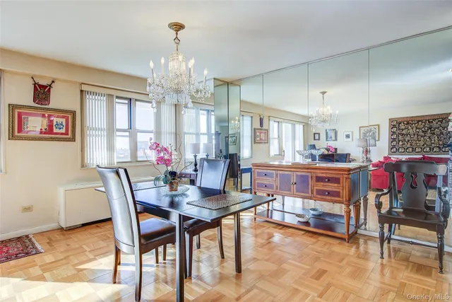 a living room with furniture a dining table and a chandelier