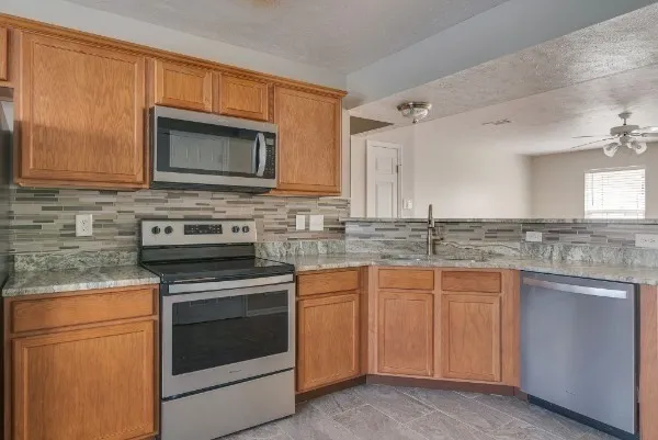 a kitchen with granite countertop a stove sink and microwave
