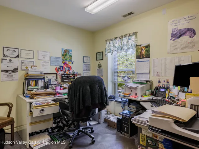 a view of a workspace with furniture and a window