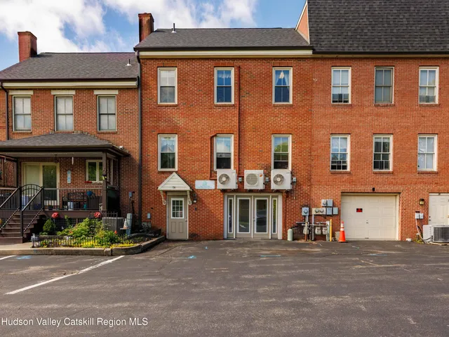 front view of a brick house with a yard