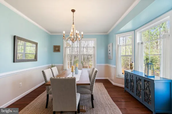a view of a dining room with furniture a chandelier and wooden floor