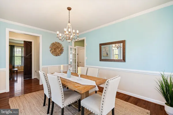 a dining room with furniture a chandelier and wooden floor