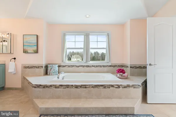 a bathroom with a granite countertop tub and a sink