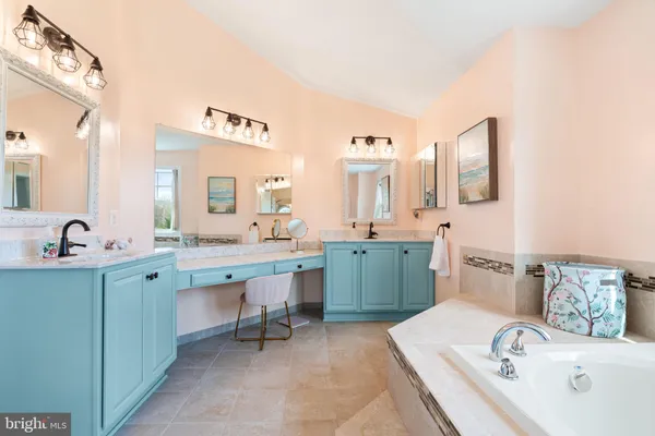 a spacious bathroom with a double vanity sink mirror and bathtub