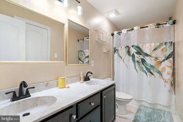 a bathroom with a granite countertop sink a toilet and a mirror
