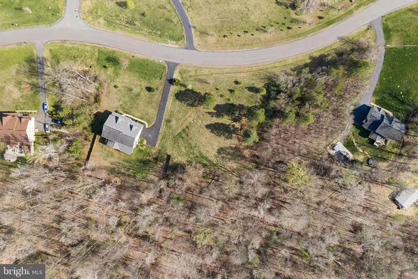 a view of a white house with a big yard and large trees