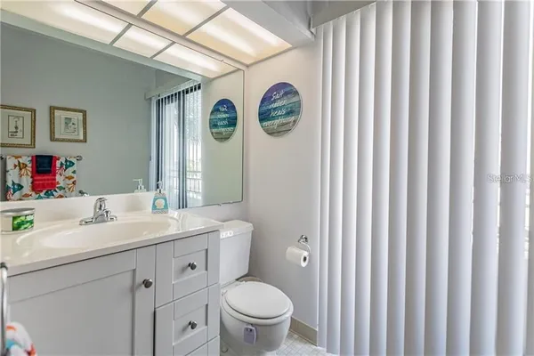 a bathroom with a toilet a sink and a large mirror