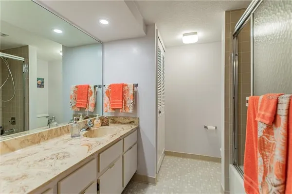a bathroom with a granite countertop double vanity sink and mirror