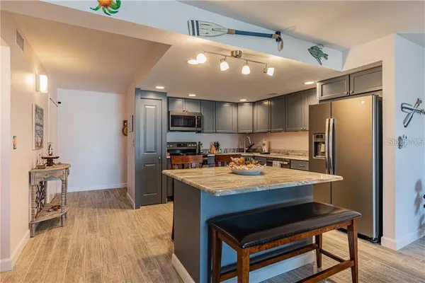 a kitchen with stainless steel appliances granite countertop a refrigerator a sink and a stove