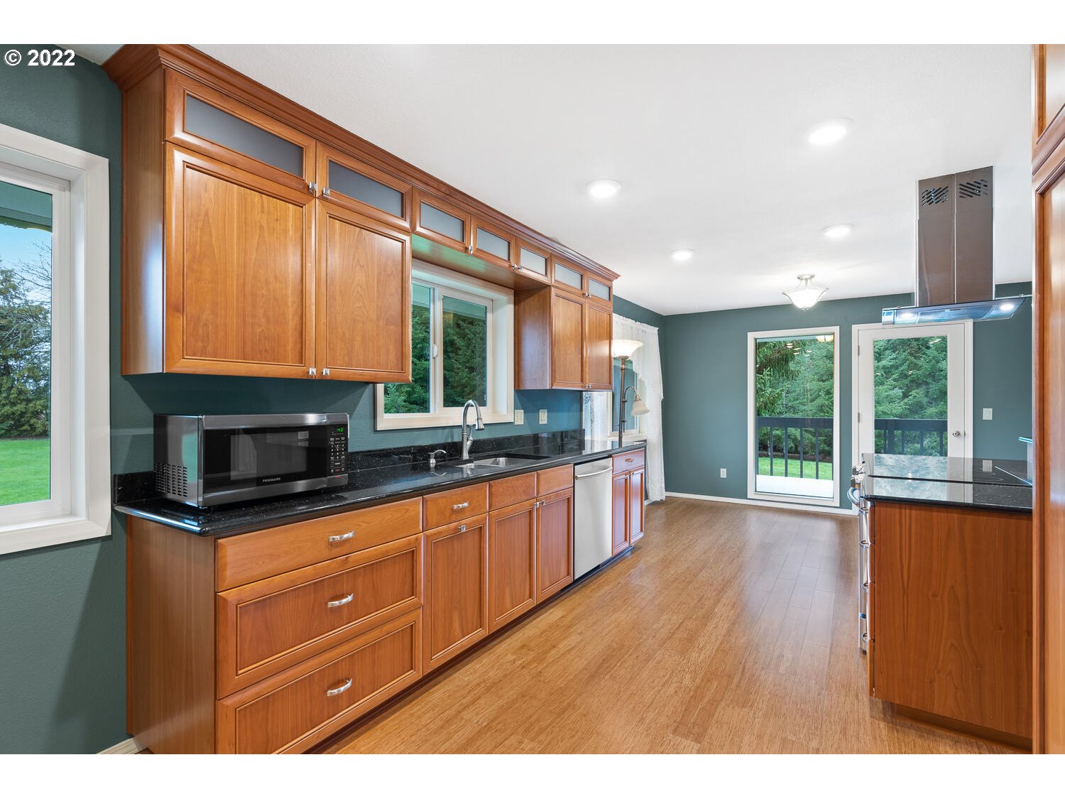 21114 Northwest 43rd Avenue Ridgefield, WA 98642 - Photo 11 of 32 a kitchen with granite countertop a stove a sink and a microwave