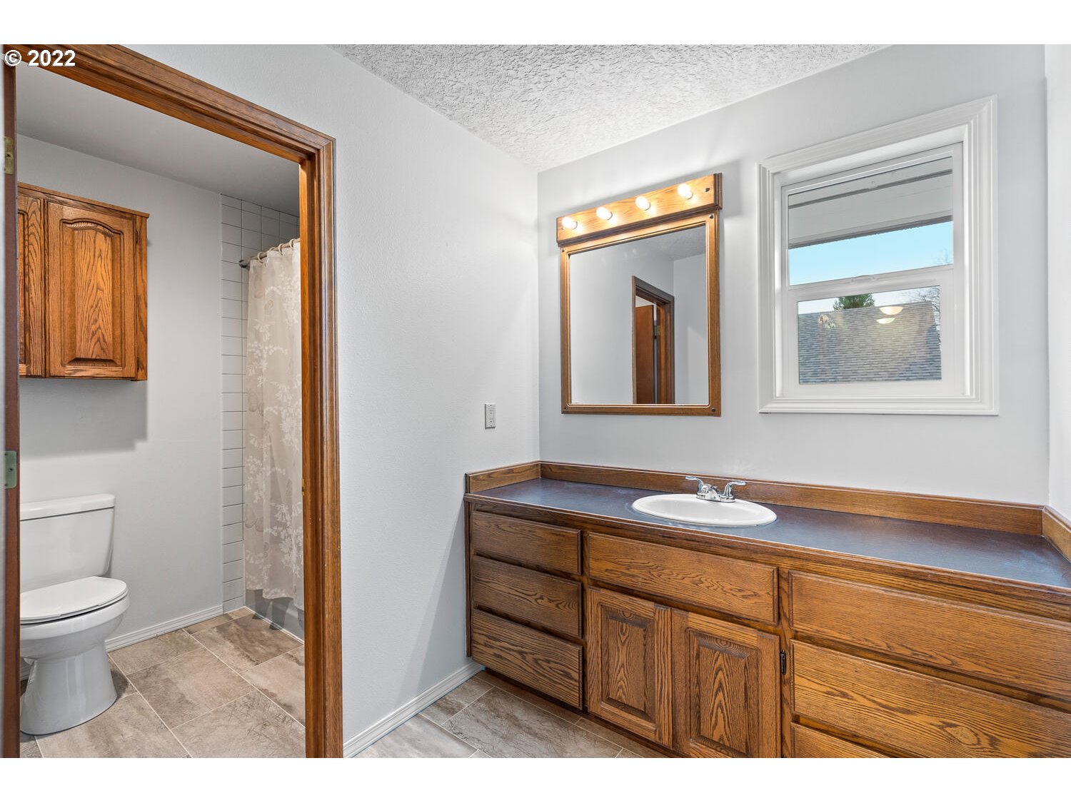 21114 Northwest 43rd Avenue Ridgefield, WA 98642 - Photo 25 of 32 a bathroom with a toilet a sink a vanity and mirror
