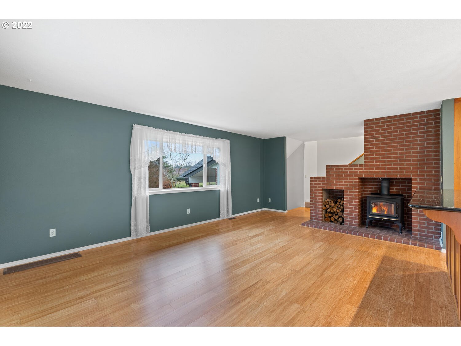 21114 Northwest 43rd Avenue Ridgefield, WA 98642 - Photo 8 of 32 a view of an empty room with a fireplace and a window