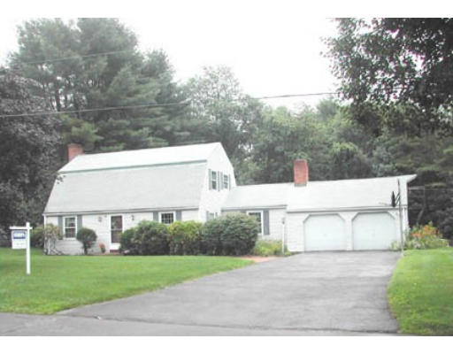 a view of a white house with a yard and a large tree