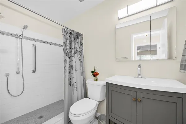 a bathroom with a sink a toilet and shower
