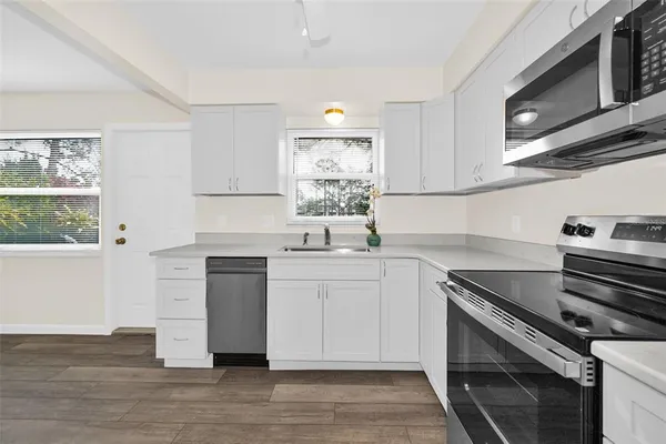 a kitchen with a stove microwave and sink