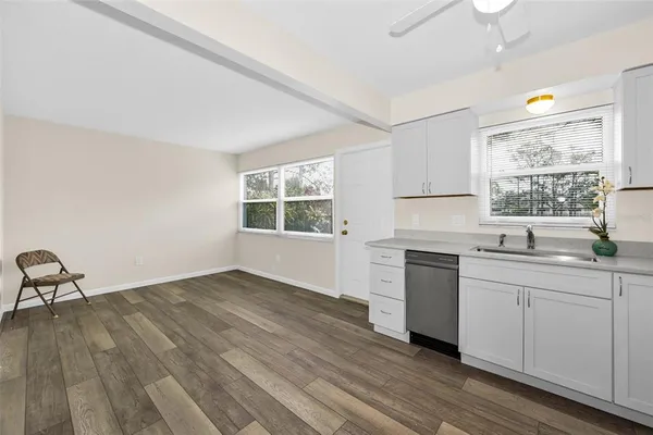 a kitchen with a sink wooden floor and window