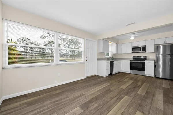 a view of kitchen with wooden floor electronic appliances and window