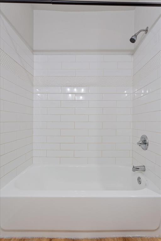 3109 North 20th Street Waco, TX 76708 - Photo 14 of 24 Bathtub-shower combination featuring white subway tile surround with a decorative penny tile accent band, polished chrome fixtures, and a curved shower rod