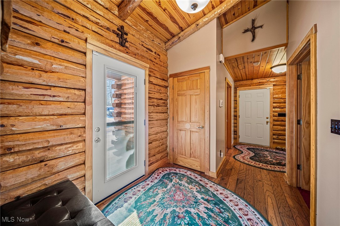282 South Ridge Road West Conneaut, OH 44030 - Photo 6 of 49 Doorway with wood ceiling, wood-type flooring, log walls, and vaulted ceiling