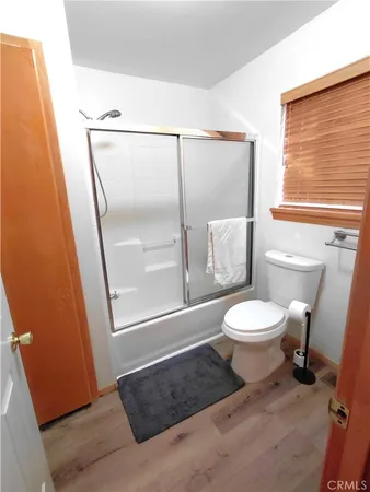 a bathroom with a granite countertop sink vanity mirror and toilet