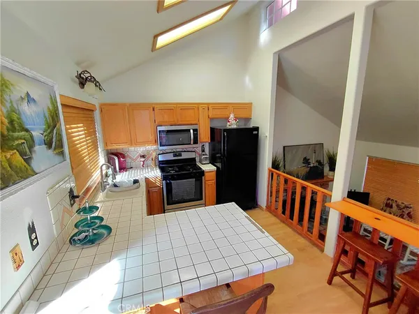 a kitchen with stainless steel appliances kitchen island granite countertop a refrigerator and a stove top oven