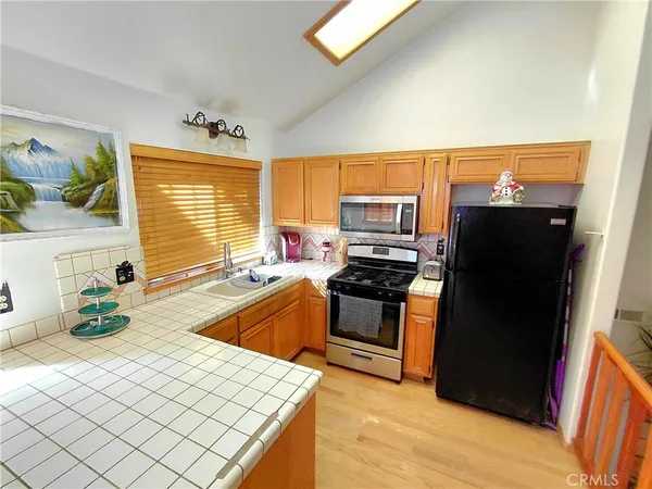 a kitchen with stainless steel appliances granite countertop a refrigerator stove and sink